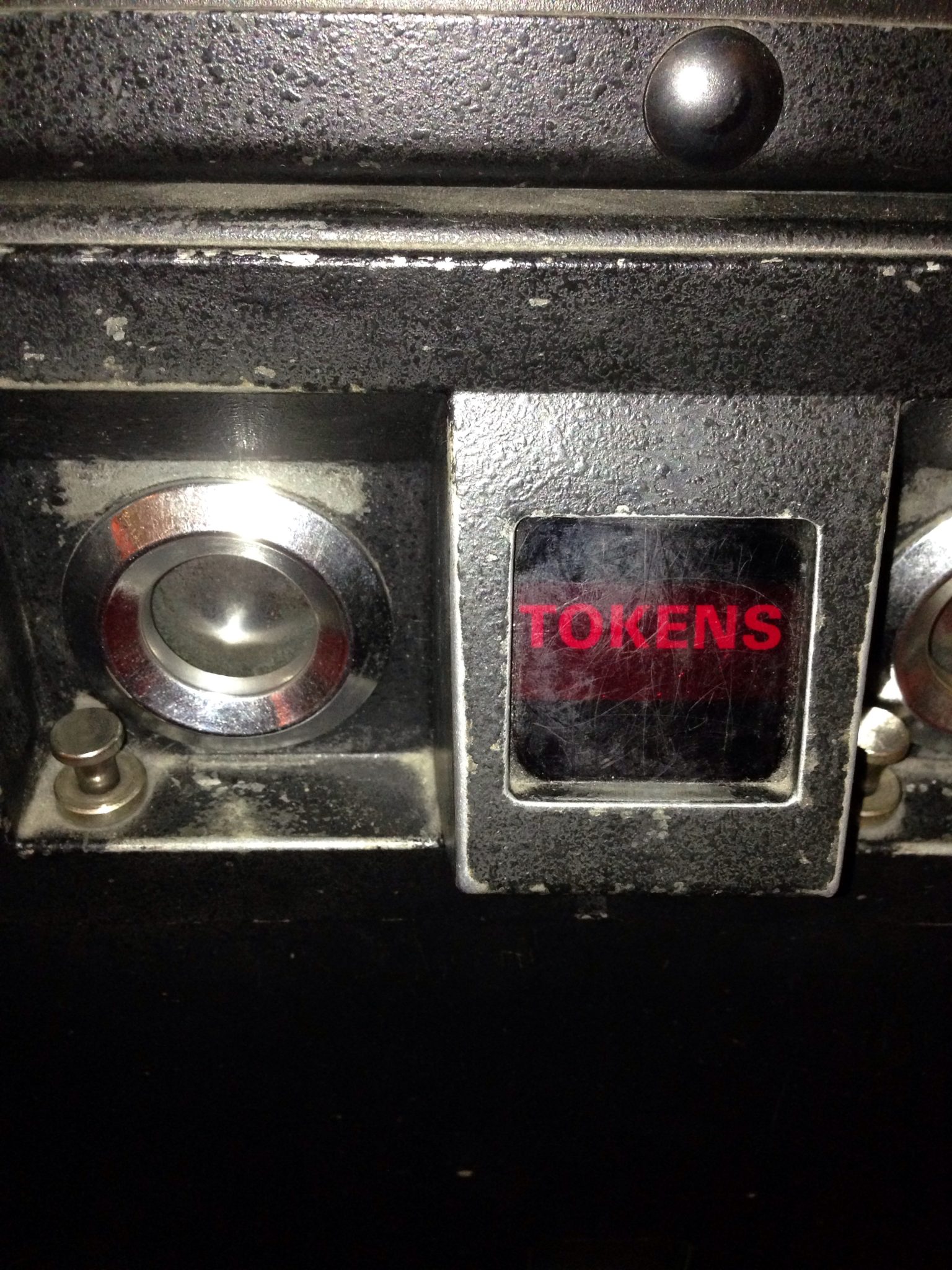 A token slot on an arcade game cabinet.